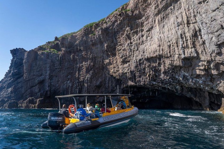 Un bote con pasajeros cerca de una costa rocosa. 3