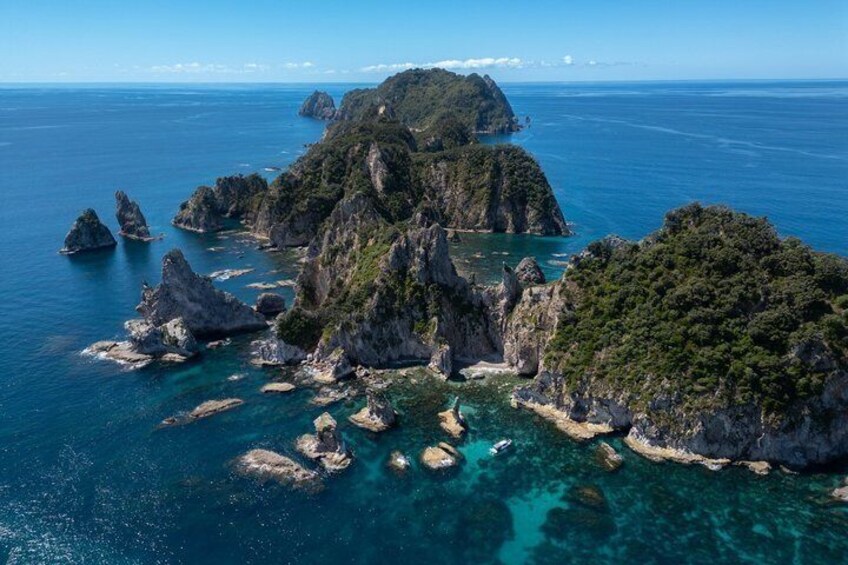 A coastal landscape with rocky outcrops and clear turquoise waters. 1