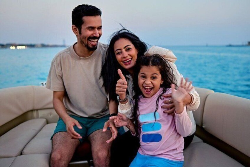 A family on a boat with a body of water and a distant shoreline in the background. 5