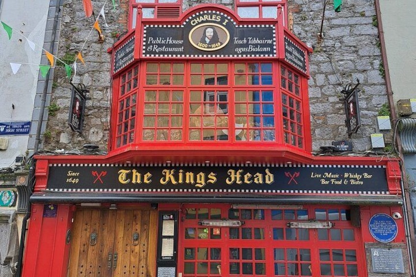 Un bâtiment rouge avec une enseigne indiquant « The King’s Head » et « Bar-restaurant ouvert au public ». 2