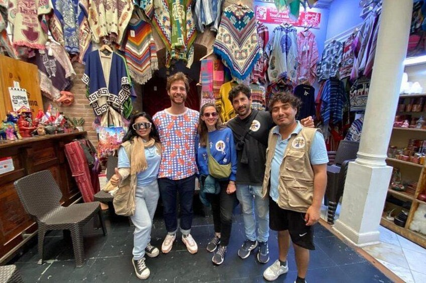 A group of people in a clothing store with various garments and accessories on display. 1