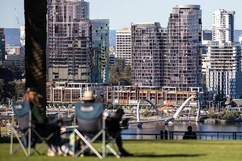 A cityscape with modern buildings, a bridge, and a body of water. 3