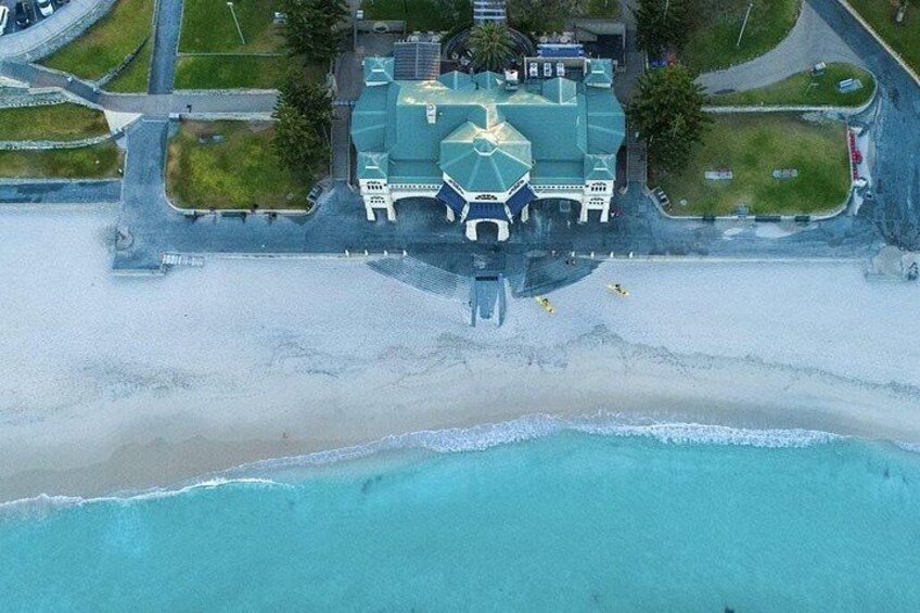 Vista aérea de una zona costera con un edificio grande, una playa y una carretera. 3