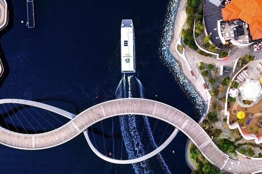 A bridge with a boat crossing it, surrounded by water and land with buildings. 5