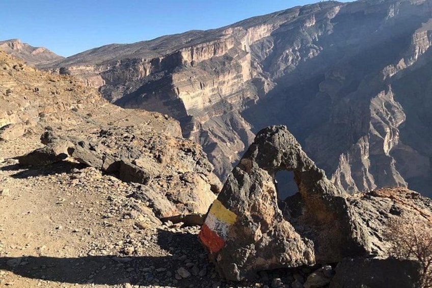 A rugged mountainous landscape with a prominent rock formation featuring a flag. 1