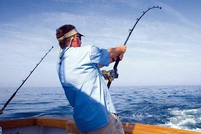 A person fishing on a boat in the ocean. 1