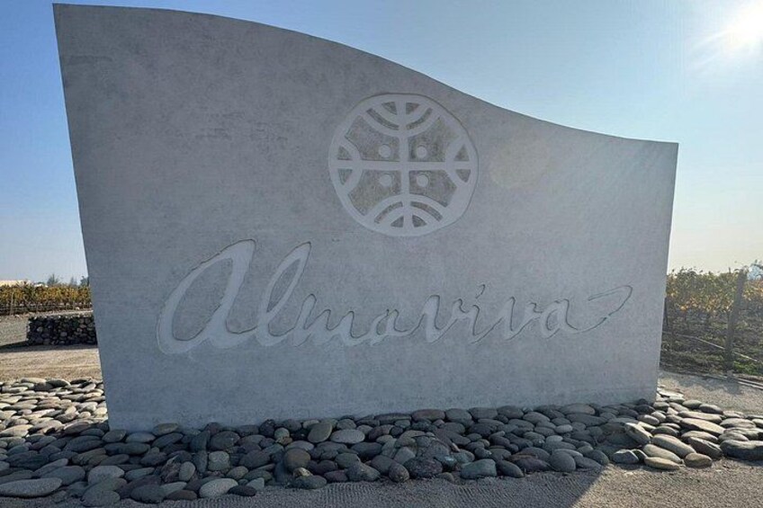 A large, curved stone sign with the word 'Almaviva' and a logo. 2
