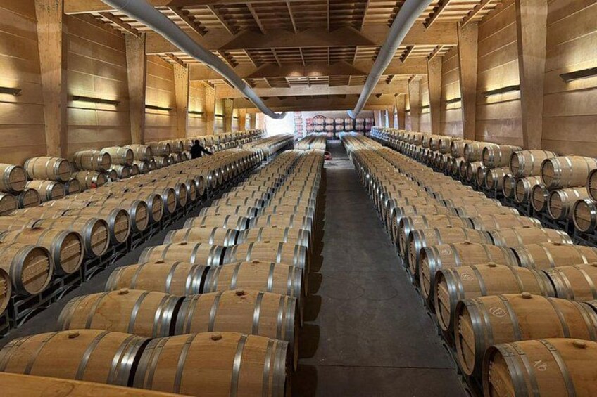 A warehouse with rows of wooden barrels. 3