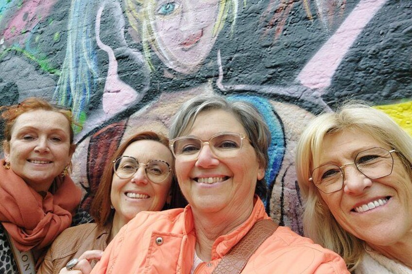 En gruppe mennesker foran en farverig væg med graffiti. 5