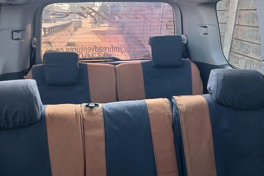 The interior of a vehicle with two rows of seats, each with a headrest and a seatbelt. 3