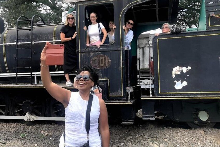 Una persona tomándose un selfie con un tren antiguo al fondo. 5