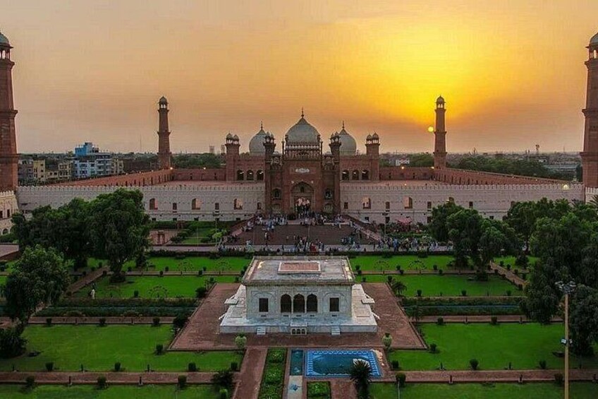 A large historical building with a central dome and minarets, surrounded by well-maintained gardens and a pool. 5
