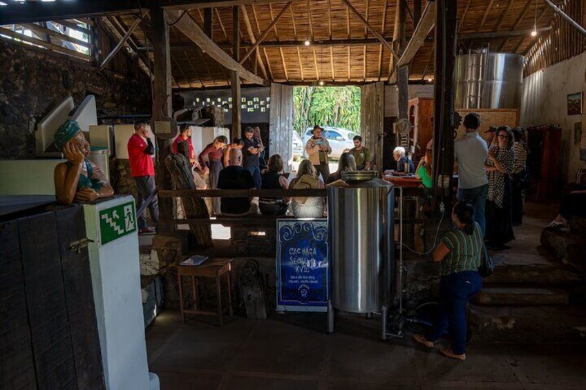 A rustic indoor setting with people gathered around a central table, possibly for a meal or event. 5
