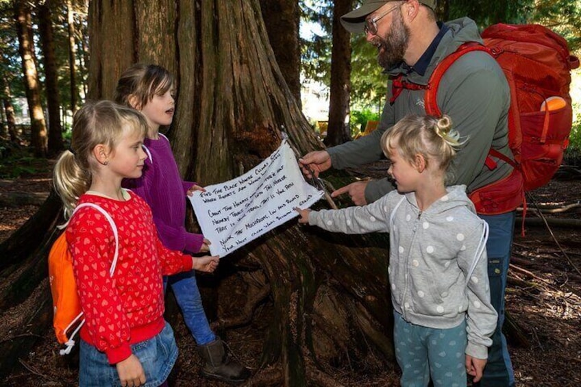 A group of people in a forest holding a sign. 1