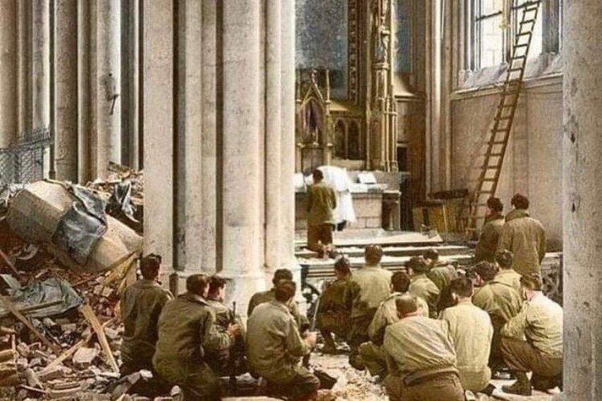 A group of people in a dilapidated building with columns, debris, and a ladder. 5