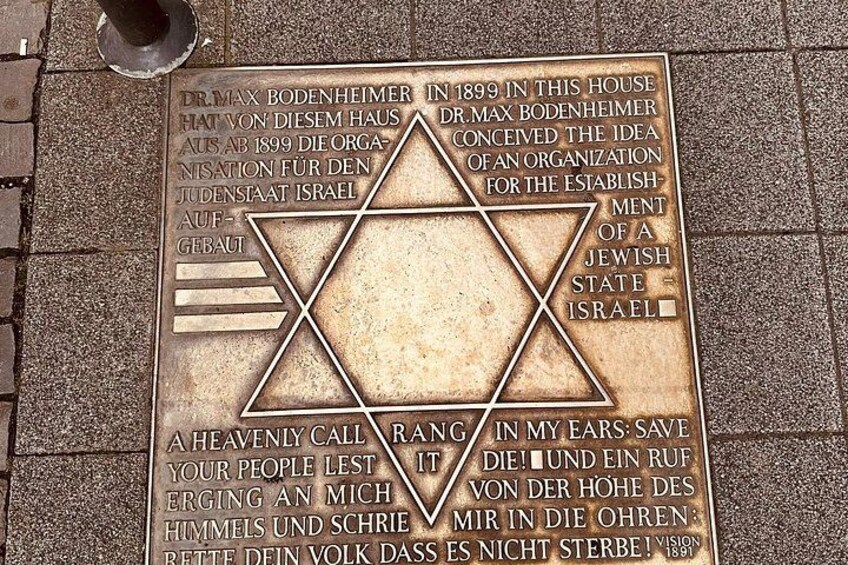 A metal plaque with Hebrew text and a Star of David. 1