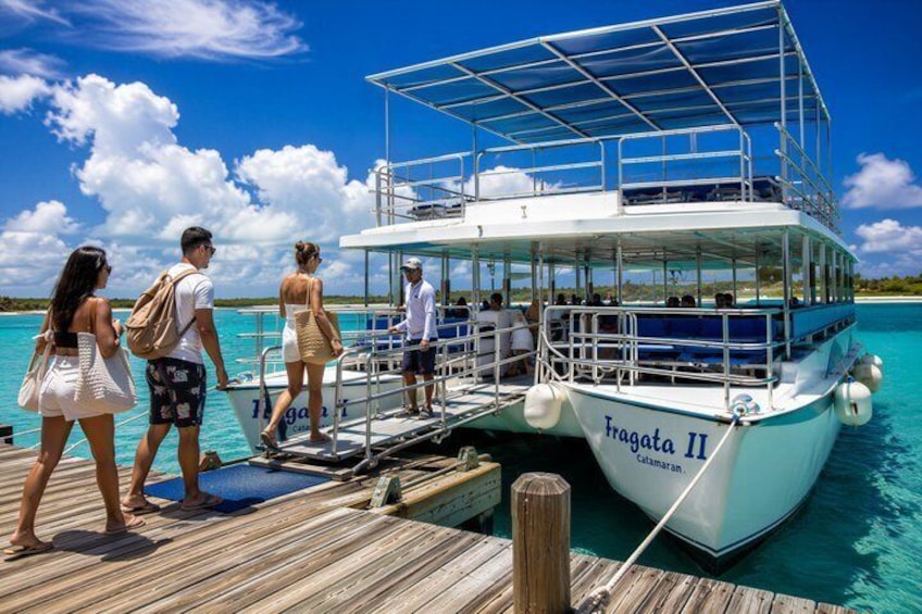A boat named 'Fragata II' docked at a pier with clear turquoise water and a wooden deck. 2