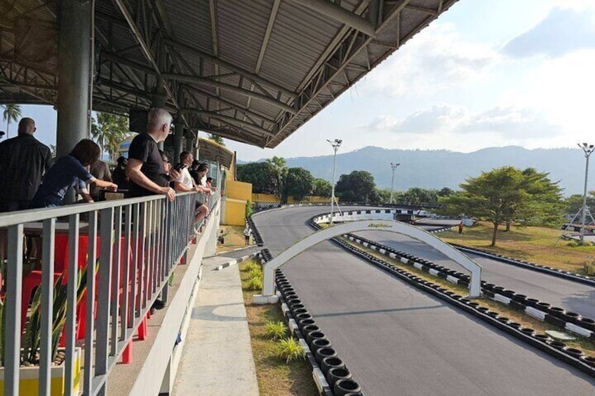 Une piste de course avec des spectateurs placés sous une zone abritée. 3