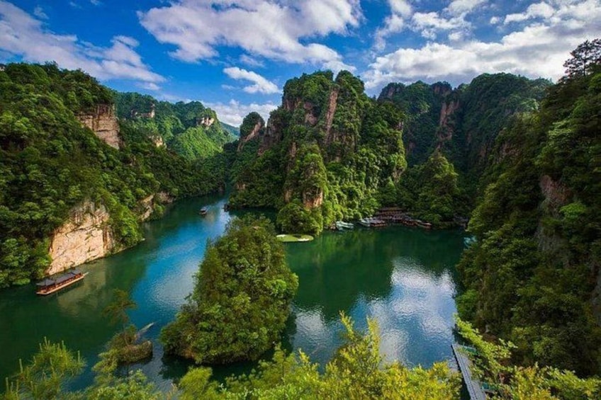 A river surrounded by lush greenery and cliffs. 1
