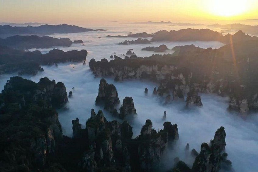 A misty landscape with rock formations and a sunrise. 5