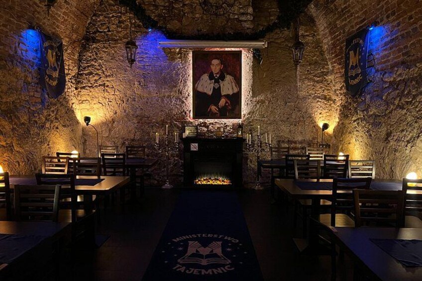 Un restaurante con paredes de piedra, mesas de madera y un cartel en la pared. 2