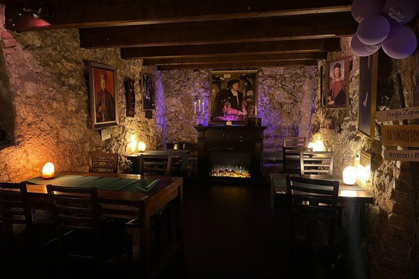Una habitación tenuemente iluminada con paredes de piedra, muebles de madera y una chimenea. 3