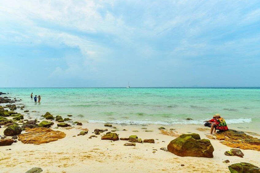 Une plage avec des rochers et des gens. 4