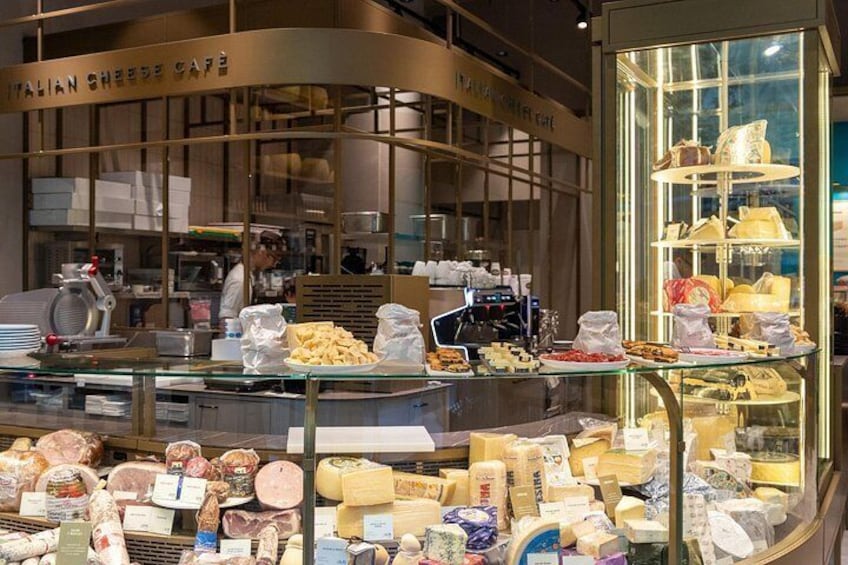 An Italian cheese shop with a variety of cheeses on display. 2