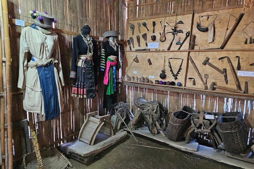 Poppen in traditionele kleding, een presentatie van houten gereedschap en geweven manden. 3