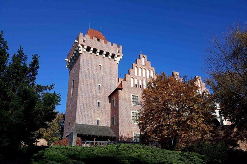 A large brick building with a prominent tower and arched windows. 5
