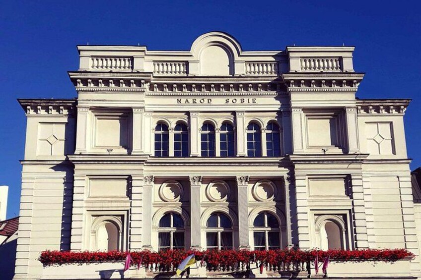A classical building with arched windows and a central entrance. 3