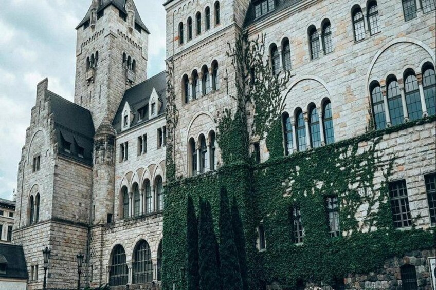 A historic stone building with arched windows and a tower. 2