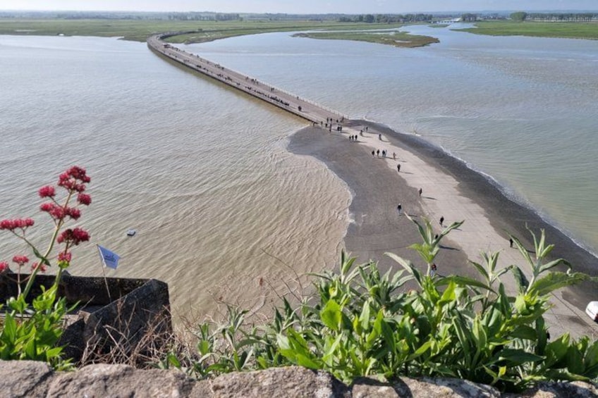 A river with a long, narrow bridge and a sandy beach. 4