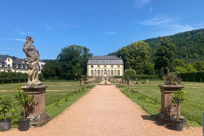 En sti, der fører til en stor bygning flankeret af statuer. 5