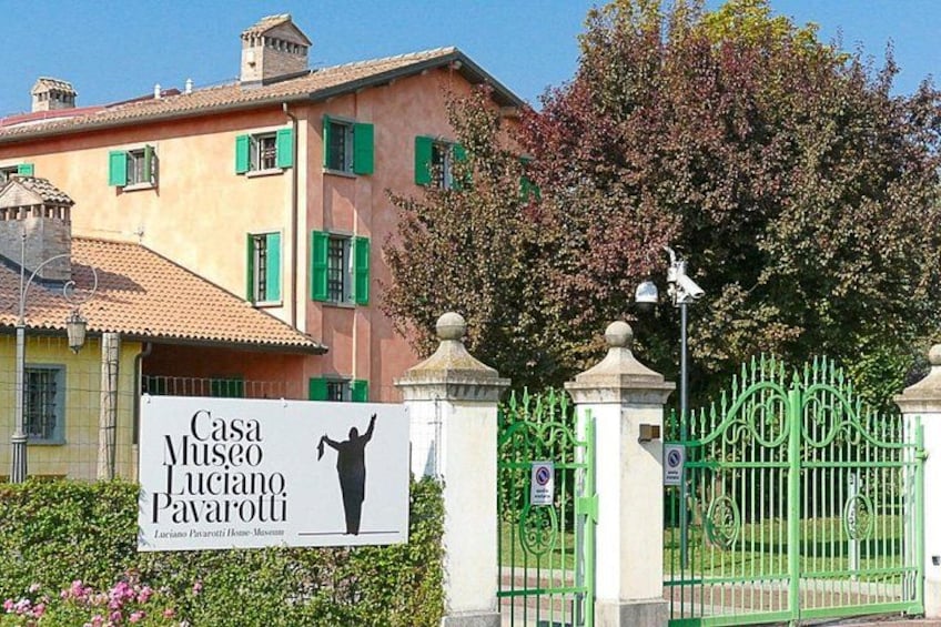 En byggnad med en skylt som lyder: ”Casa Museo Luciano Pavarotti”. 3