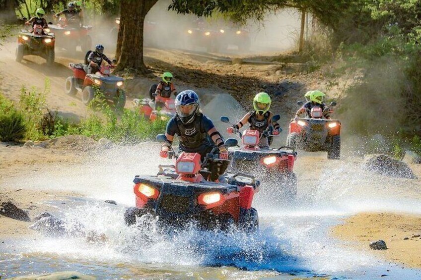 Persone che guidano quad attraverso una pista sterrata. 4