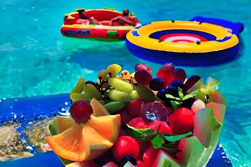 A pool with floating rings and a basket of fruit. 5