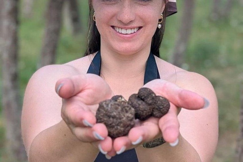 A person holding several dark-colored objects. 1