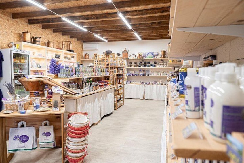 Un interior rústico con estantes de madera, un mostrador y varios productos envasados. 5