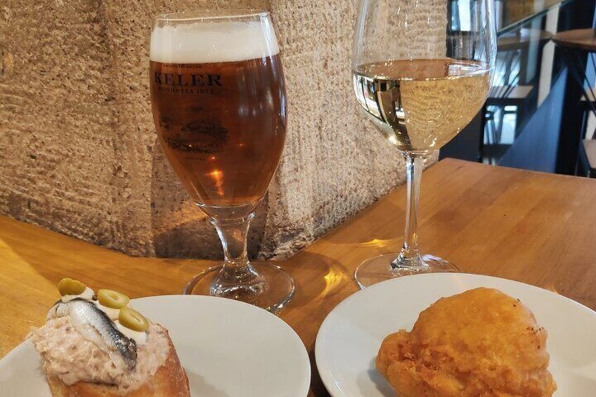 Et træbord med to tallerkener mad og to glas med drikke. 4