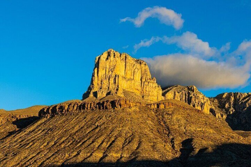 A rugged mountain with a prominent peak and layered rock formations. 5
