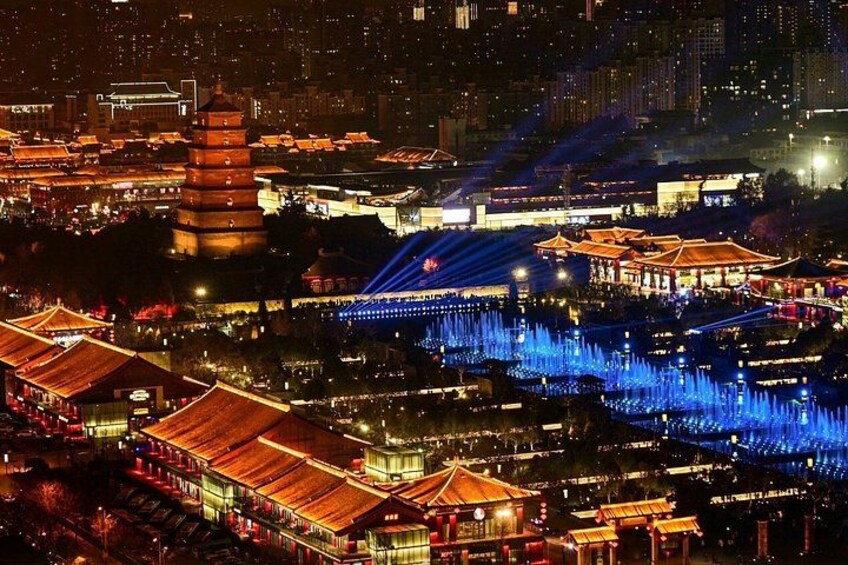 A traditional Chinese architectural complex at night with illuminated buildings and water fountains. 2