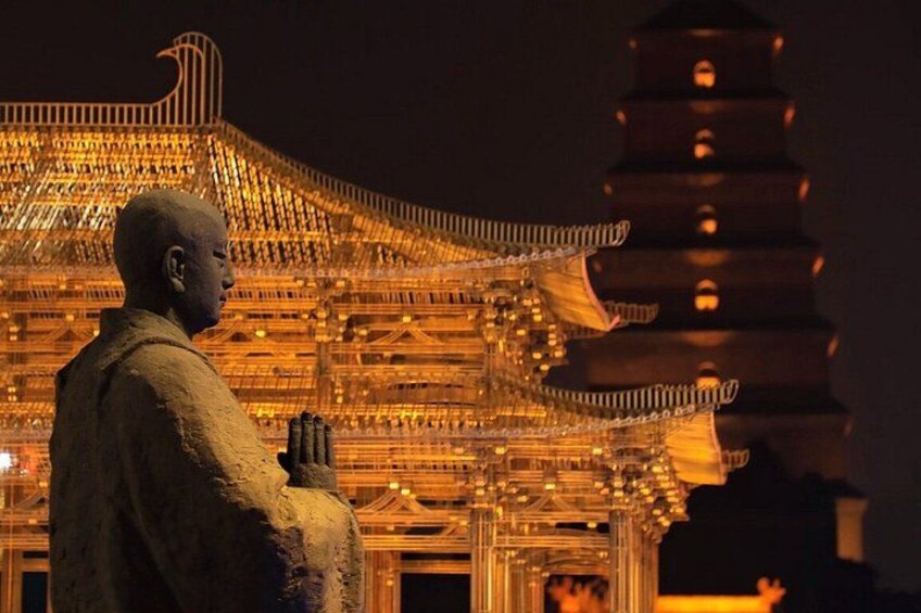 A statue of a person in traditional attire, a pagoda with multiple tiers, and a large, ornate building with intricate designs. 3