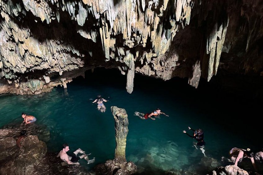 Un groupe de personnes nage dans une grotte ornée de stalactites. 2