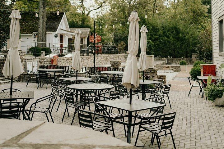 An outdoor patio with round tables and chairs, surrounded by umbrellas. 2