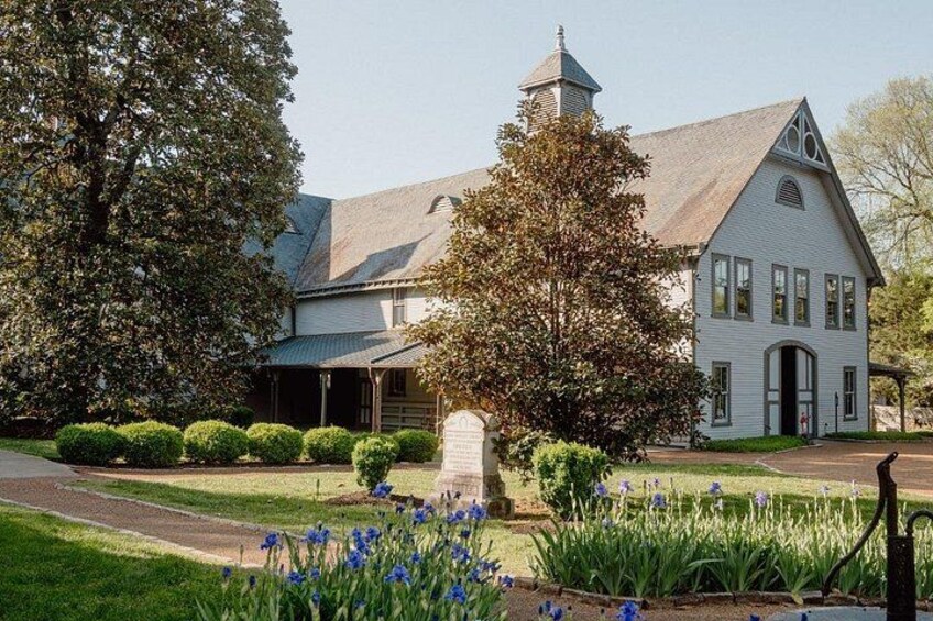 A white church with a steeple, surrounded by well-maintained lawns and flowering plants. 5