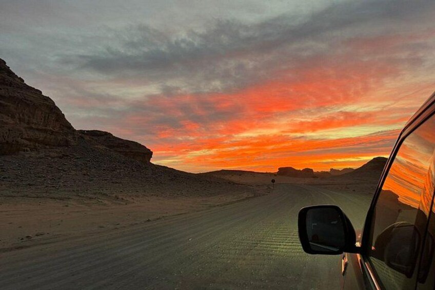 Une route désertique au coucher du soleil, le rétroviseur d’une voiture et des falaises rocheuses. 3