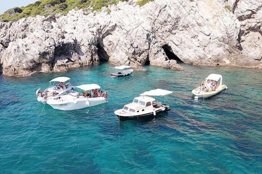A group of boats anchored near a rocky coastline. 3