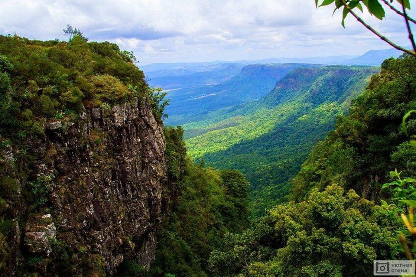 A mountainous landscape with dense green vegetation and a steep cliff. 2
