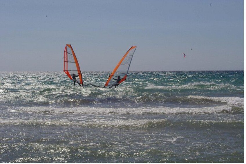 Zwei Personen windsurfen im Meer bei Wellengang. 2